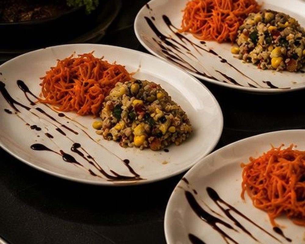 Entrées à l'assiette préparées par Le Paille en Queue : carottes râpées et taboulé, dressées au trait de réduction balsamique